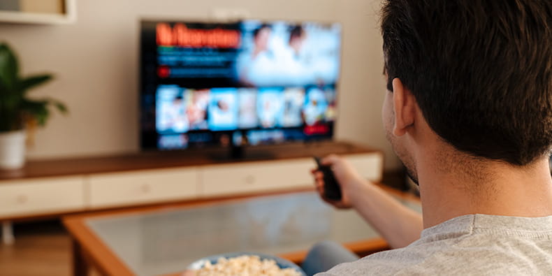 Man Sitting on a Couch Watching TV