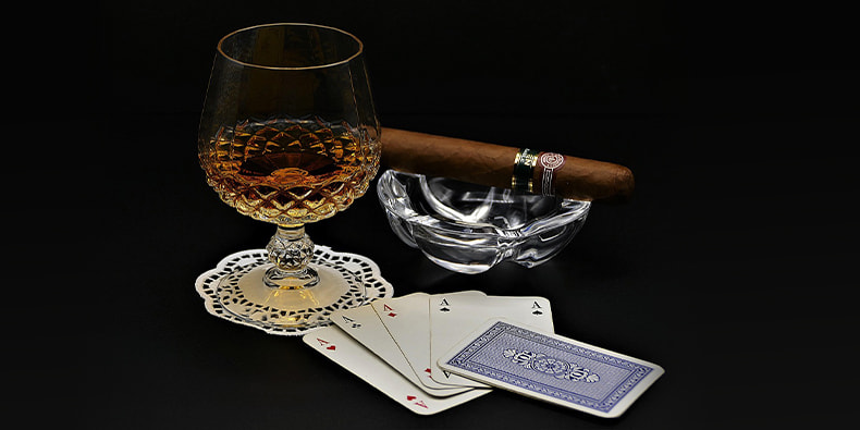 Four aces, cigar, and cognac